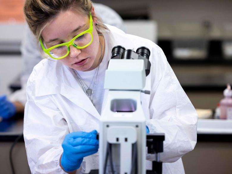 student looking at microscope 